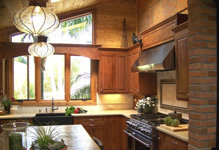 A kitchen with wood cabinets and a large island.
