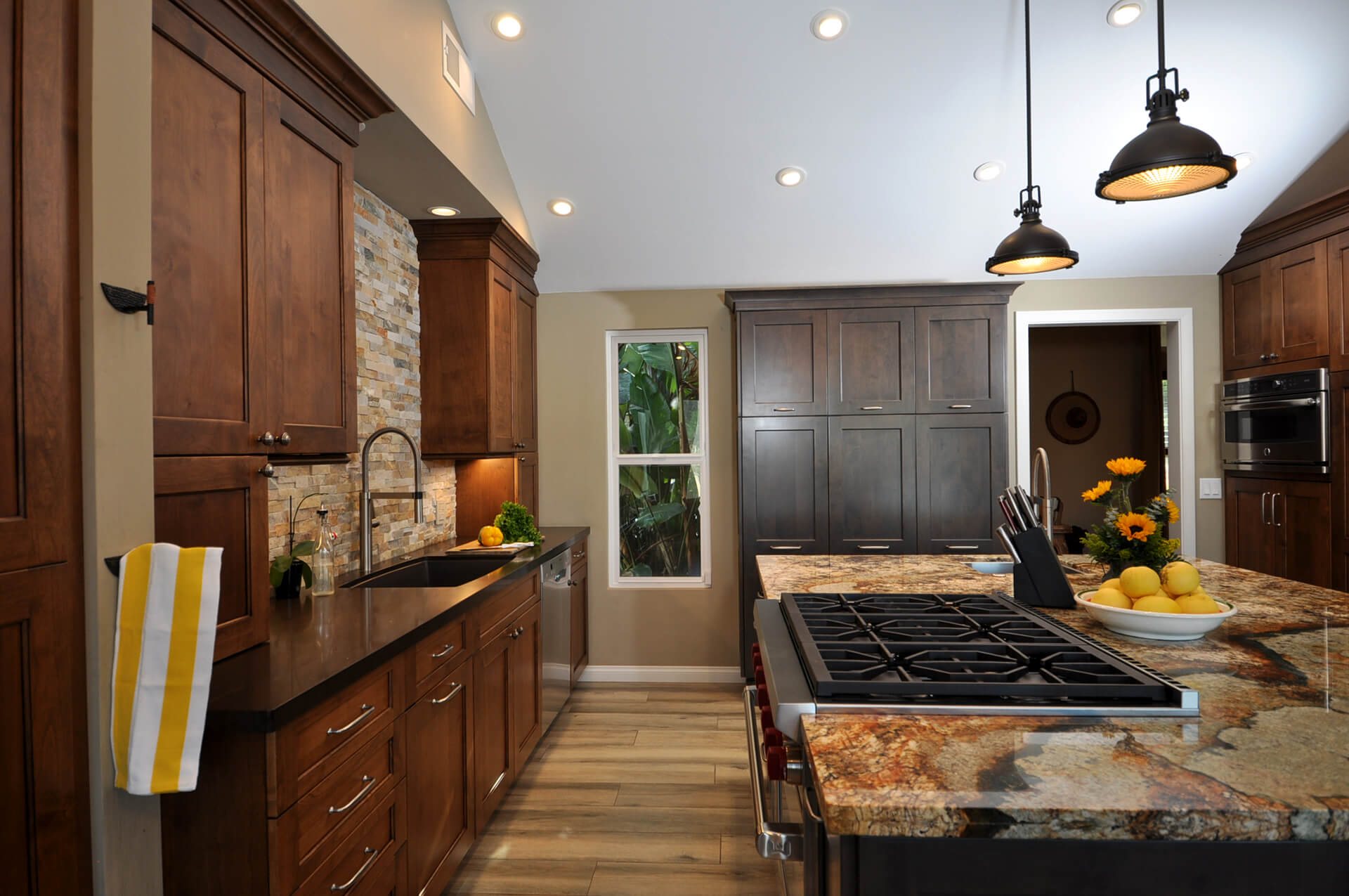 A kitchen with wood cabinets and stone counter tops.